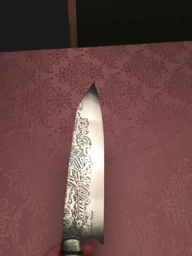 Fine line graphics laser-engraved onto a metal knife blade.